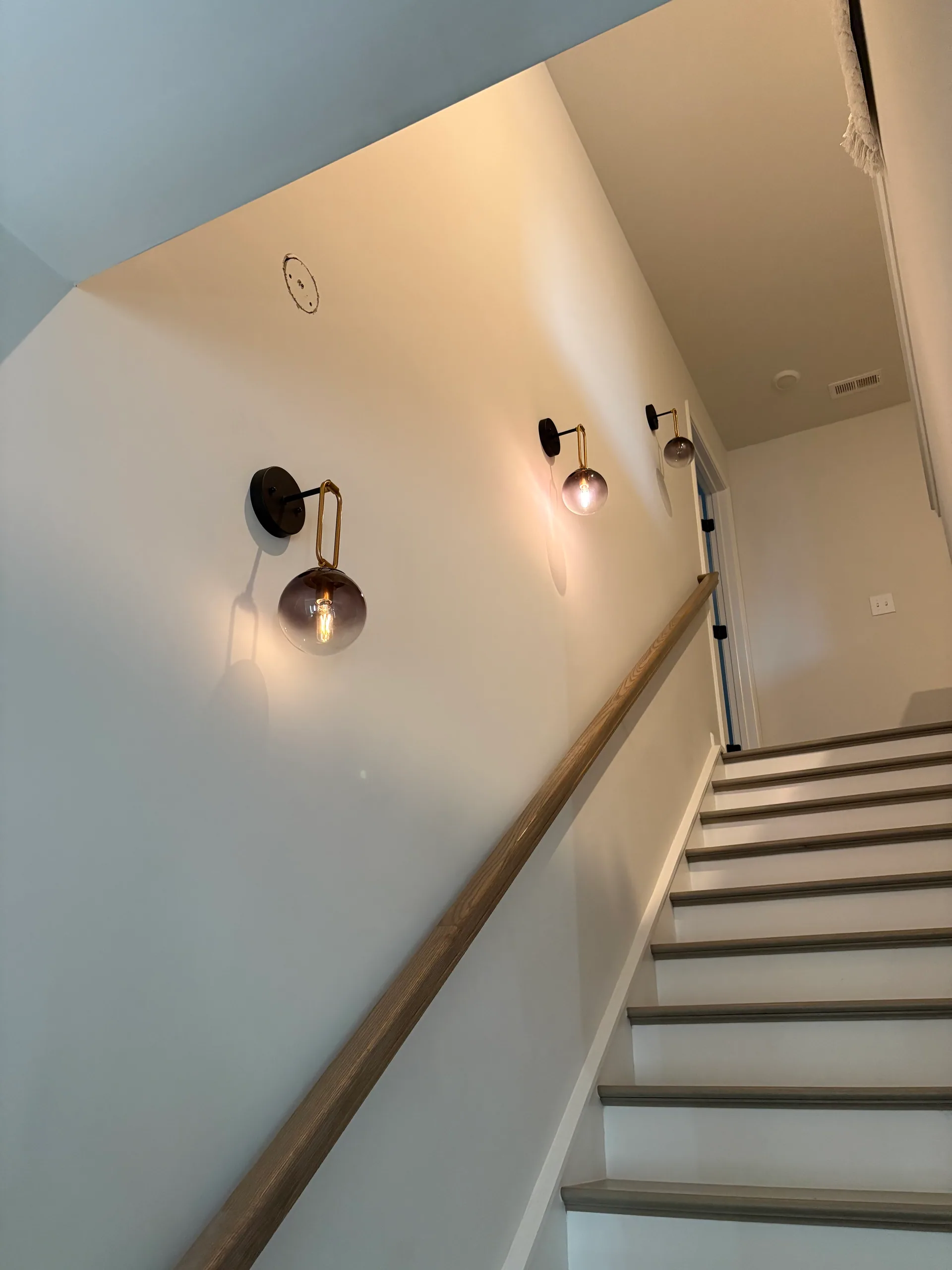 Brass arm globe sconces stair treads low angle
