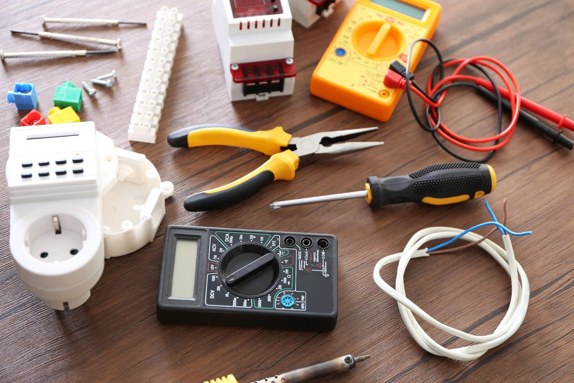 Electrician tools flat lay multimeters pliers wooden table