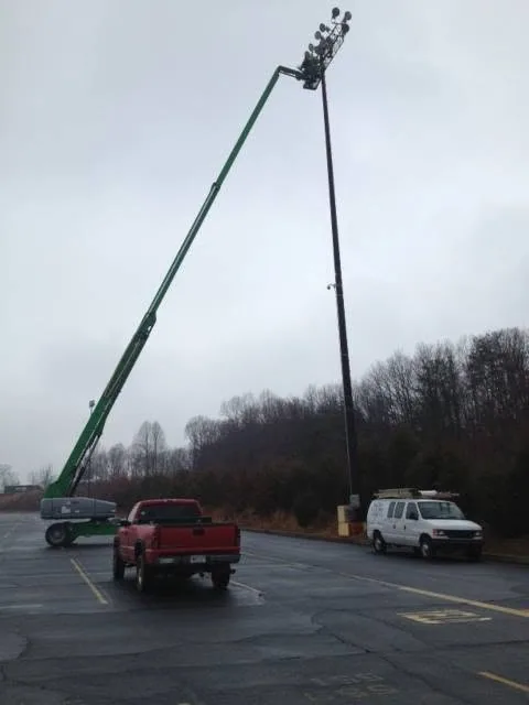 Green boom lift parking lot light pole service