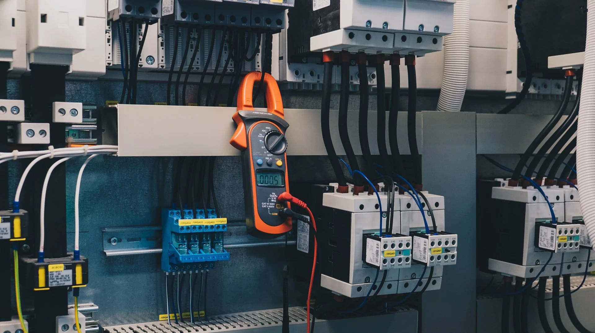 Orange clamp meter hanging contactor panel