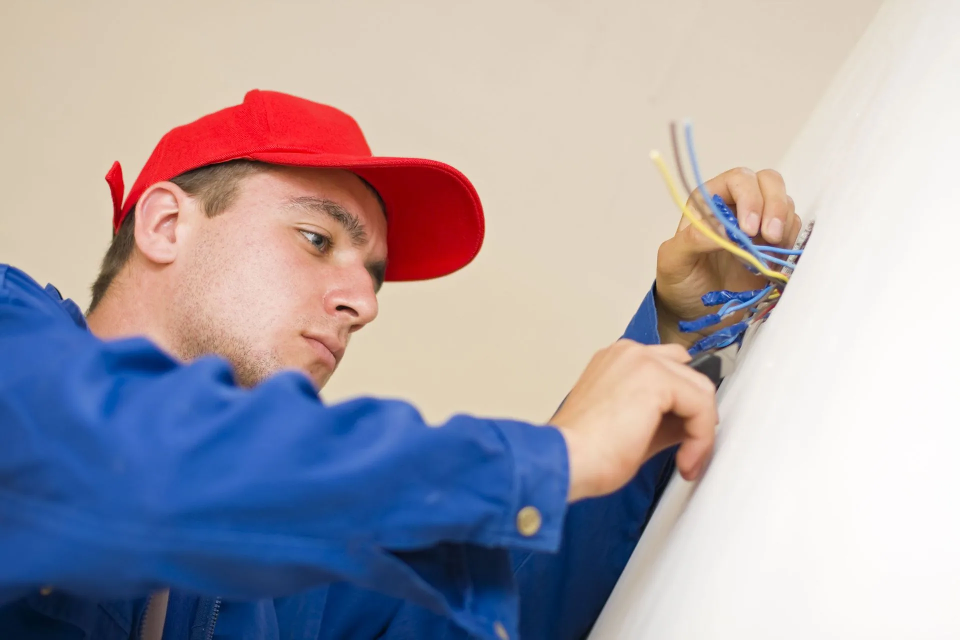 Red cap electrician wiring wall box low angle
