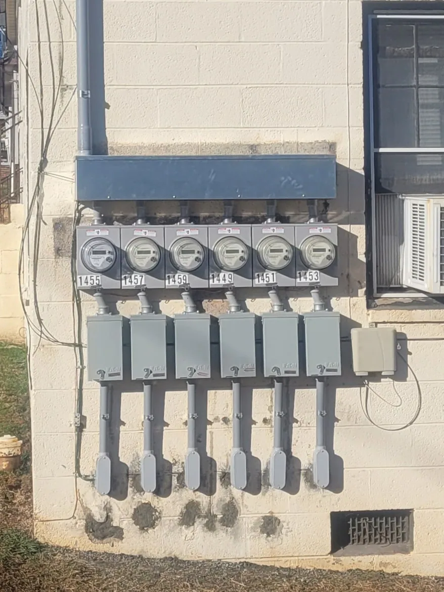 Six gang electric meter bank cinder block wall