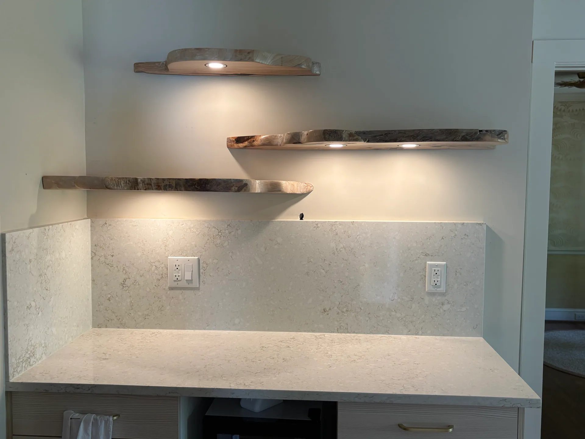 Staggered live edge shelves downlights quartz backsplash