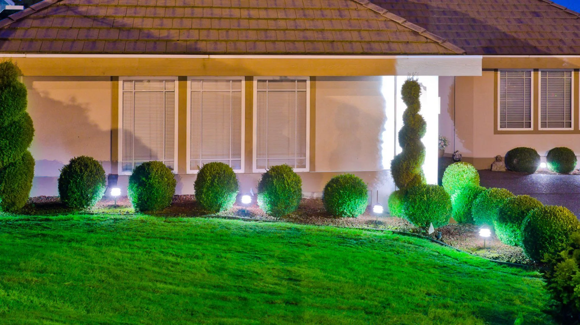Stucco home shrub bed landscape lighting night